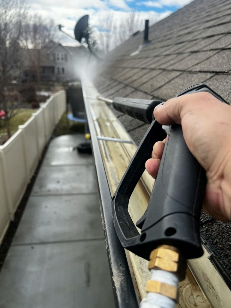 cleaning house gutters as part of routine home maintenance checklist