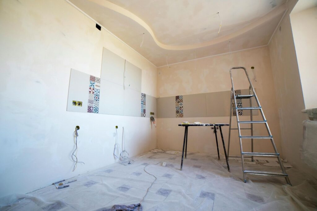 kitchen room mid-renovation with exposed wiring ladder and tiling work in progress
